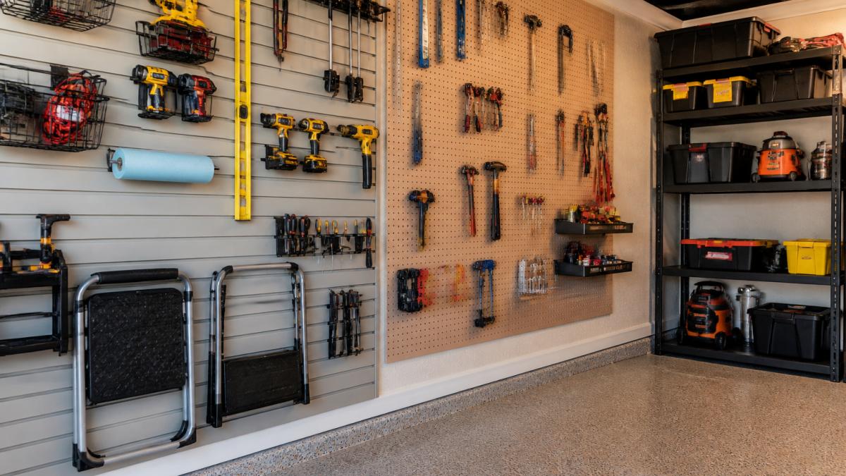 Well-organized home workshop with finished walls displaying mounted pegboards, tool racks, and shelving, showing how different wall materials support tool storage and handle wear from daily use